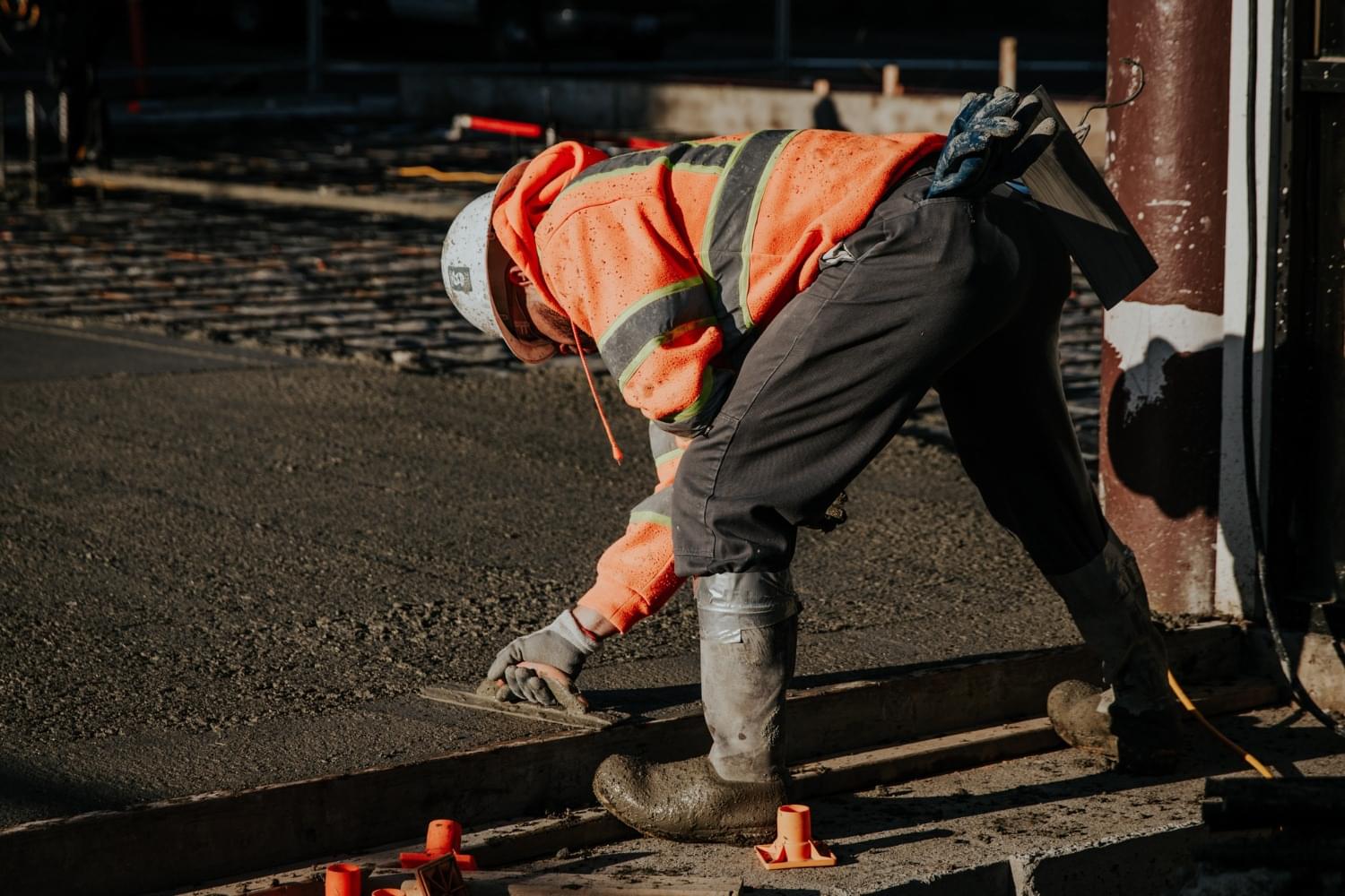 worker smoothing asphalt